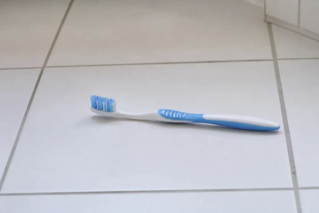 Brosse a dents posee sur un carrelage blanc propre