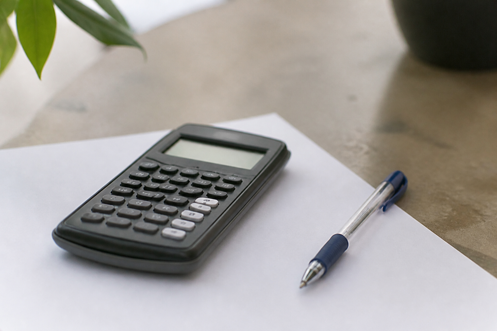 Calculatrice et stylo poses sur une feuille de papier