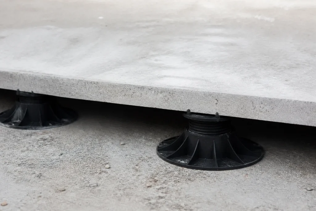 Plots reglables sous dalle beton legerement ondulee